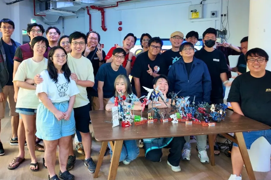 Group photo of builders behind a table of finished model kits